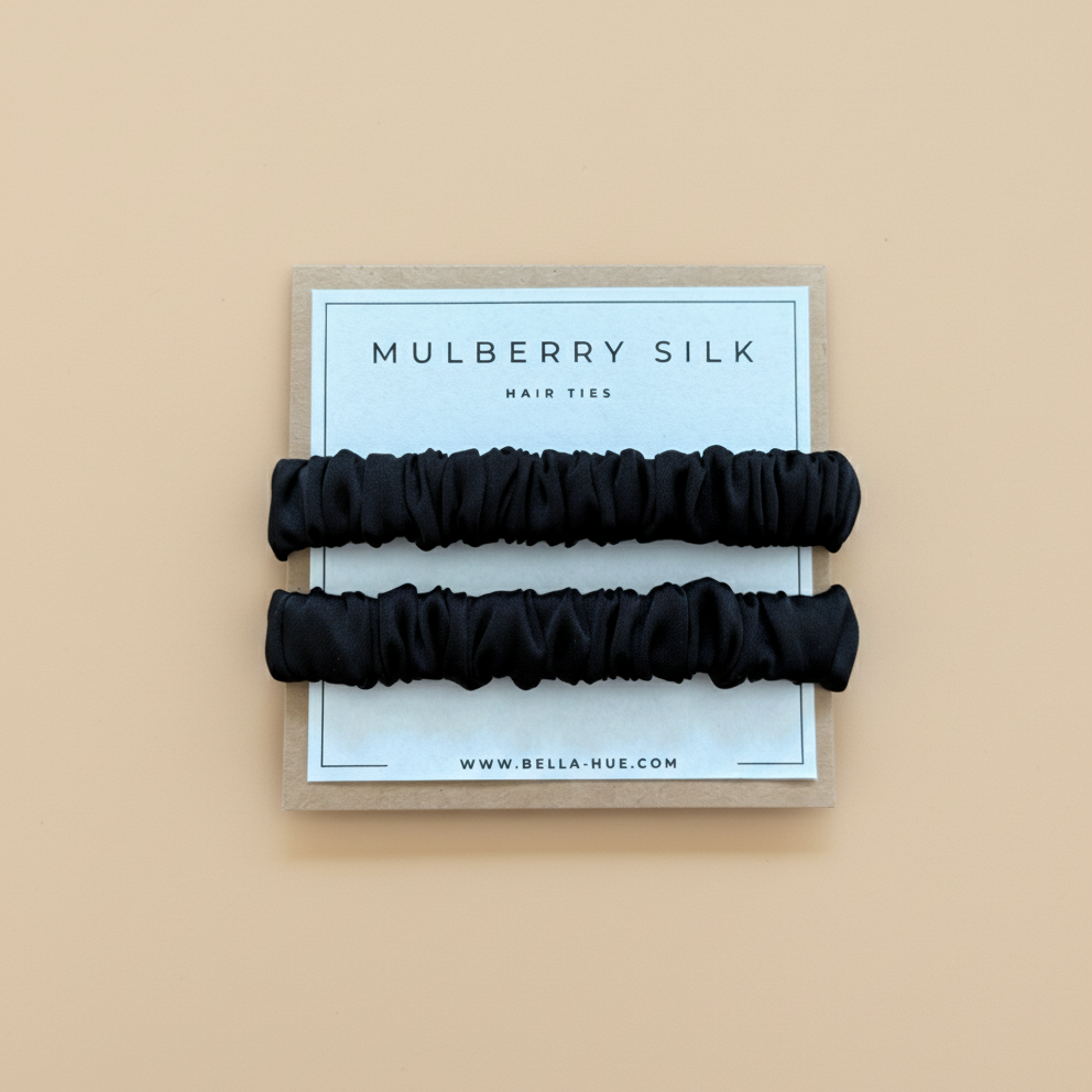 Two black mulberry silk hair ties on a Bella Hue branded card with a white background