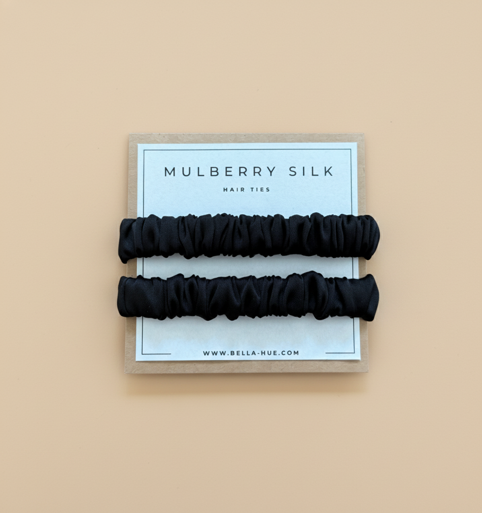 Two black mulberry silk hair ties on a Bella Hue branded card with a white background